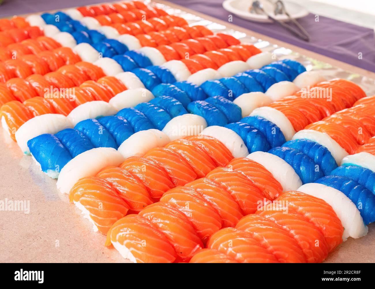 Pezzi di sushi nigiri, 140 di questi, fatti di salmone, pesce bianco e pesce bianco di colore blu disposti come una bandiera norvegese. Profondità bassa di f Foto Stock