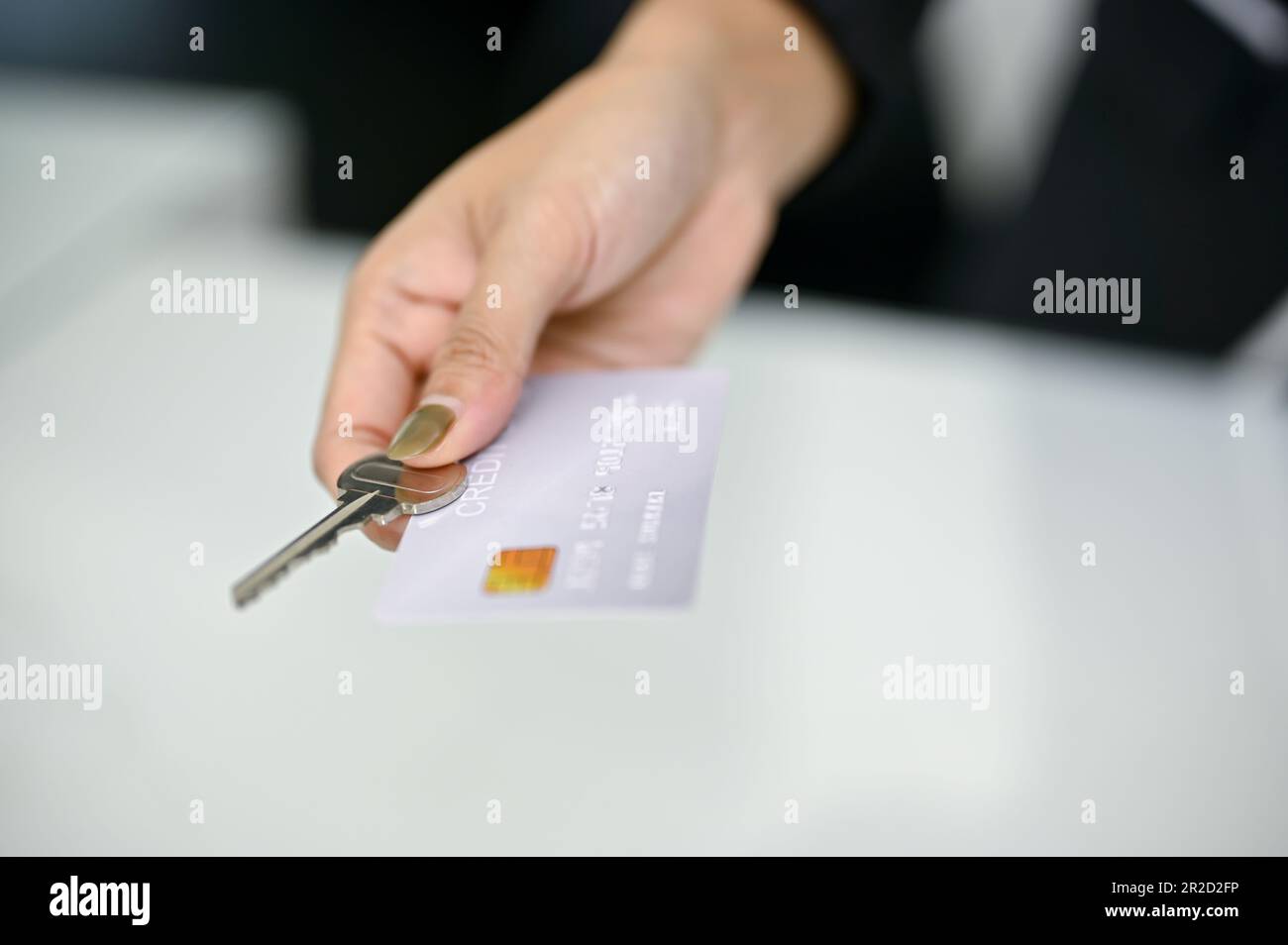 Immagine ravvicinata di un addetto alla reception che fornisce una carta di credito e una chiave della camera a un cliente alla reception. Concetto di check-in in hotel Foto Stock