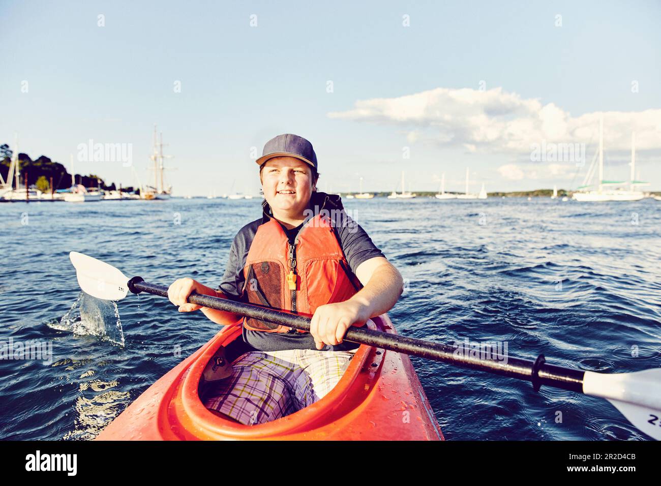 Giovane uomo in kayak al tramonto a casco Bay, Maine Foto Stock