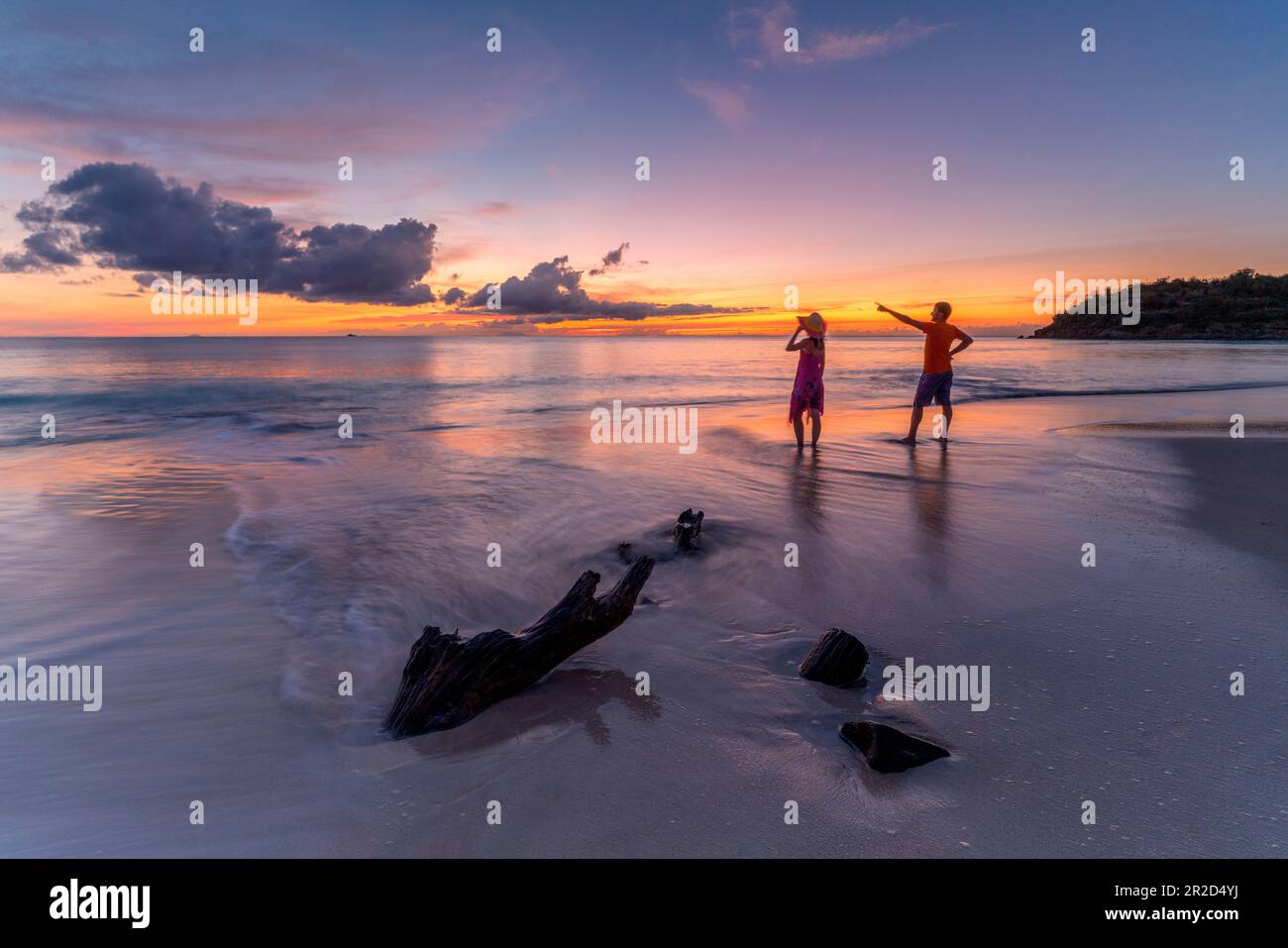 Uomo e donna ammirando il tramonto sulla spiaggia tropicale, Caraibi Foto Stock