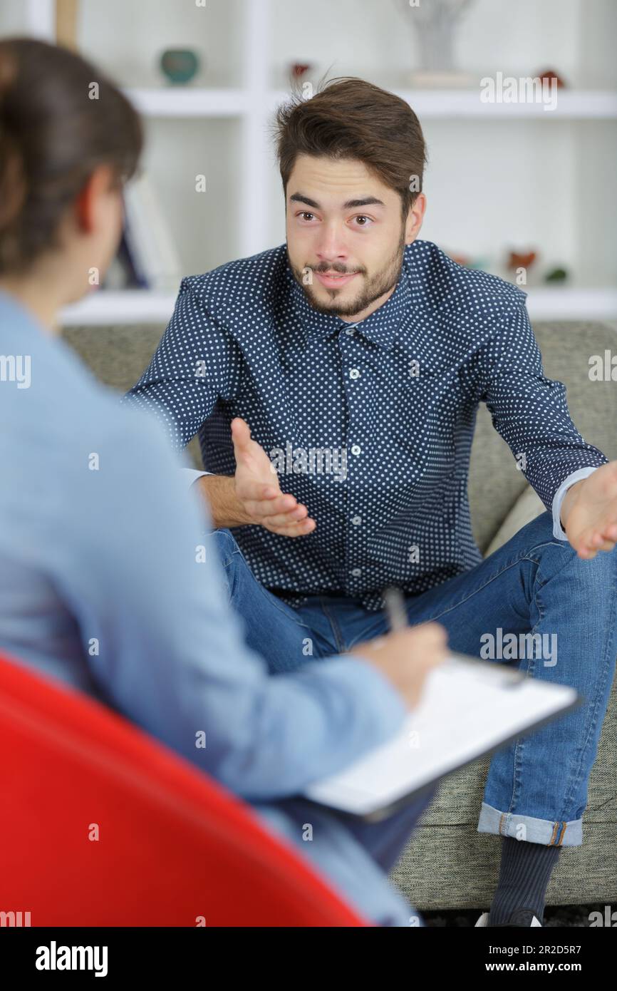 terapista seduto davanti al paziente con carta e penna Foto Stock