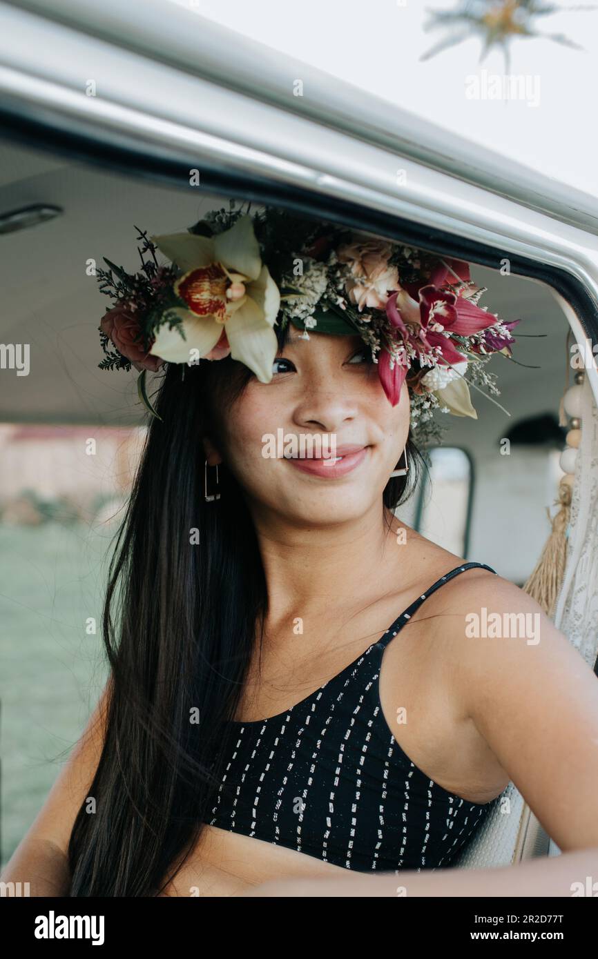 Donna asiatica felice e sorridente con un lei po'o e costume da bagno Foto Stock