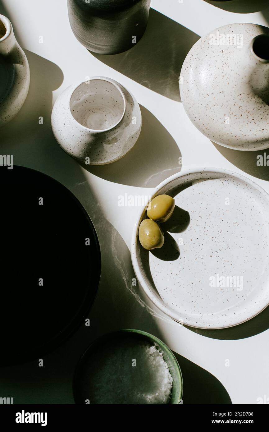 Due Olive verdi su un piatto di ceramica in studio Foto Stock