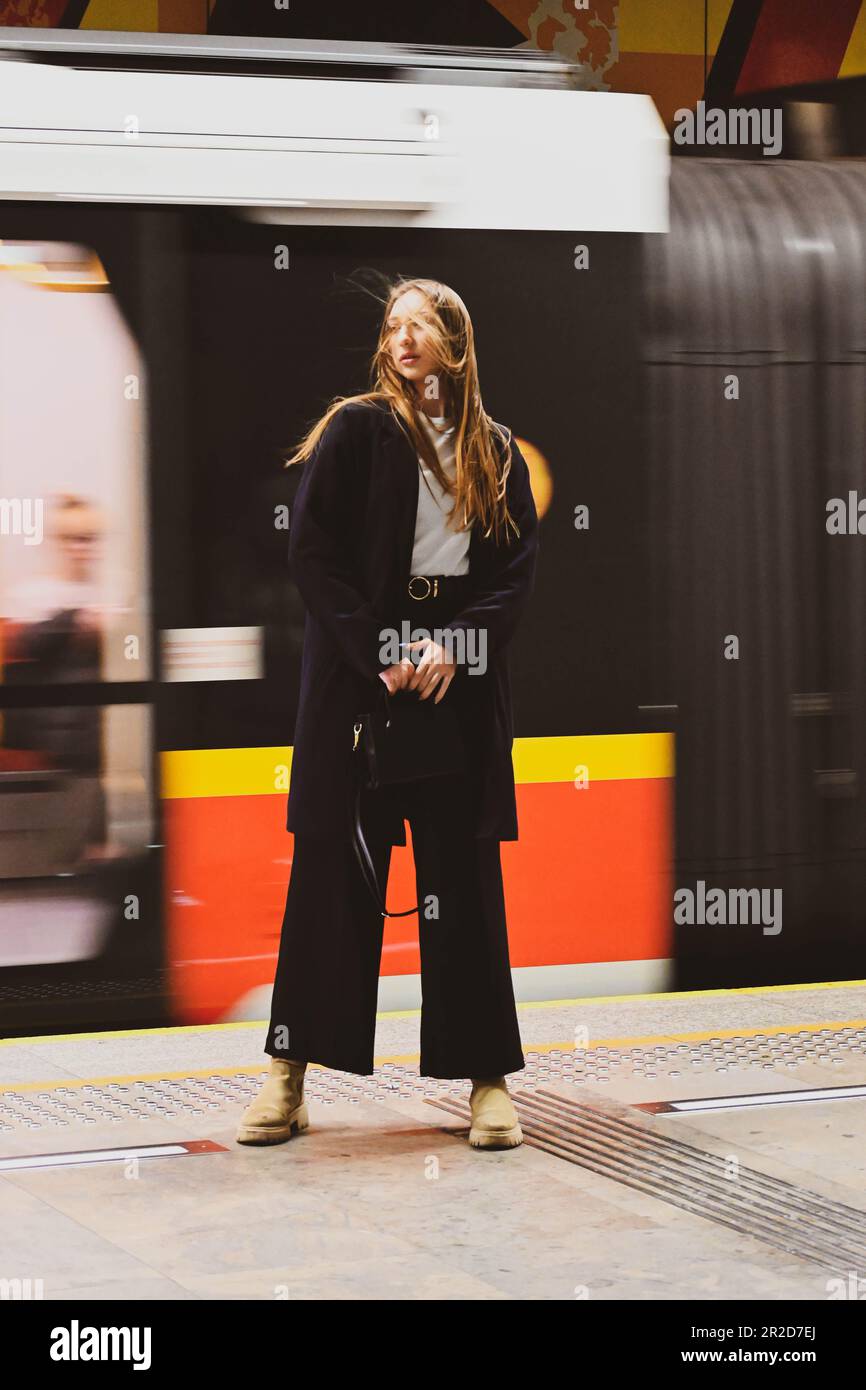 La bella ragazza bianca si trova contro il treno in metropolitana Foto Stock