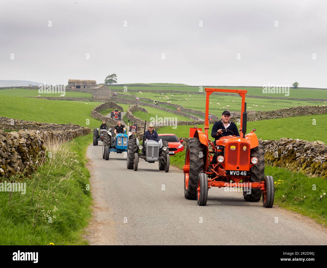 Un trattore corre su una strada sopra Settle, Yorkshire Dales, Regno Unito. Foto Stock