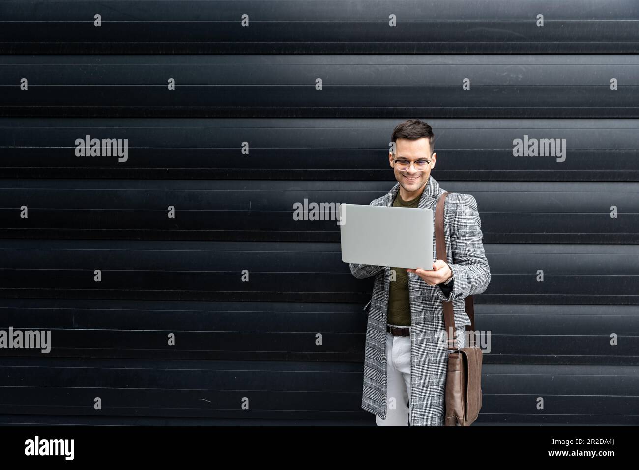 Ritratto di un giovane uomo d'affari di successo, direttore delle vendite, capo e caposquadra in piedi di fronte ad un edificio di uffici. Responsabile ed esperto della persona di affari Foto Stock