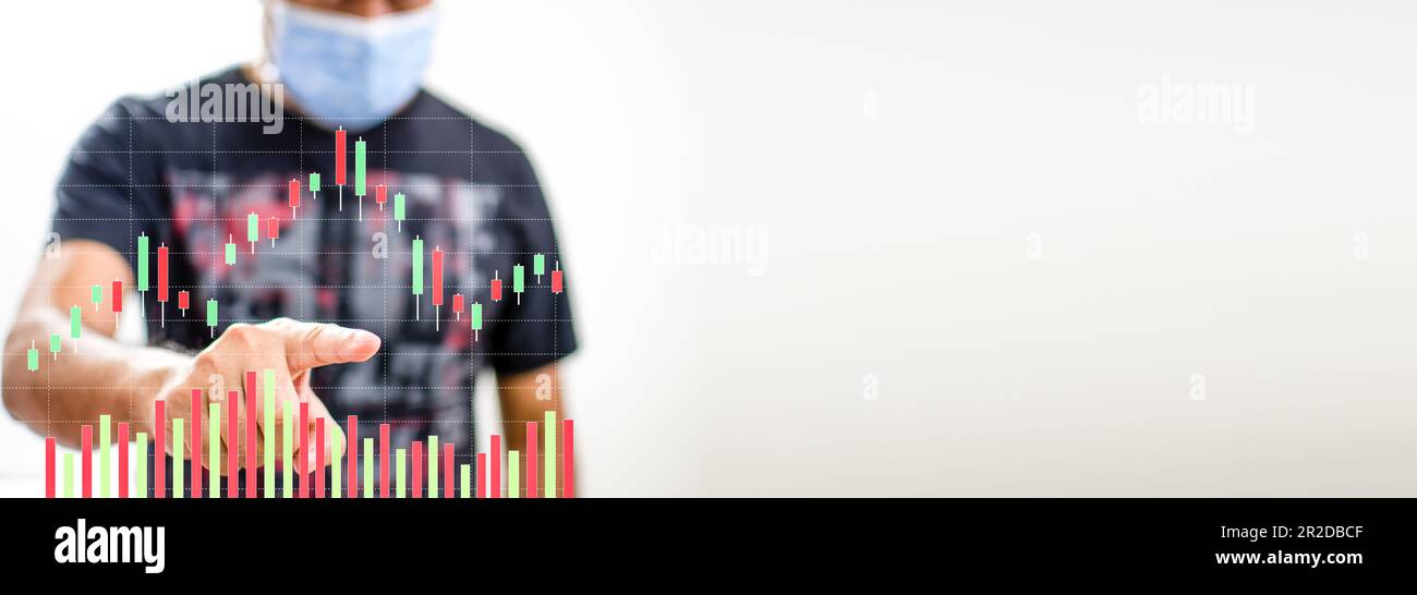 Un uomo che indossa una maschera di coronavirus, o COVID-19, sta puntando il dito su un grafico a colori che mostra l'attività di mercato durante le vacanze. Fare un primo piano p Foto Stock