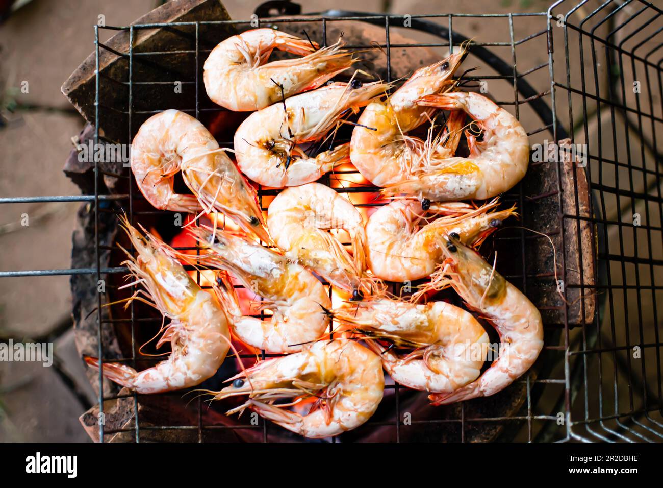 Pesce, gamberetti grigliati sulla griglia a fiamma di cenere e non fumo. La foto è una vista dall'alto e fa un primo piano. Gamberetti di colore arancione, è riscaldato Foto Stock