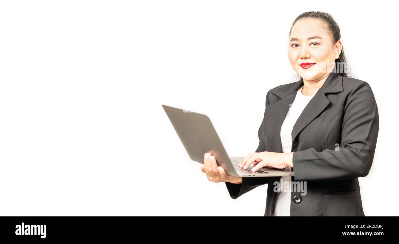 Ritratto di una felice donna d'affari asiatica sorridente e guardando la fotocamera, lavorando su un computer portatile e digitando su una tastiera, isolato su bianco Foto Stock