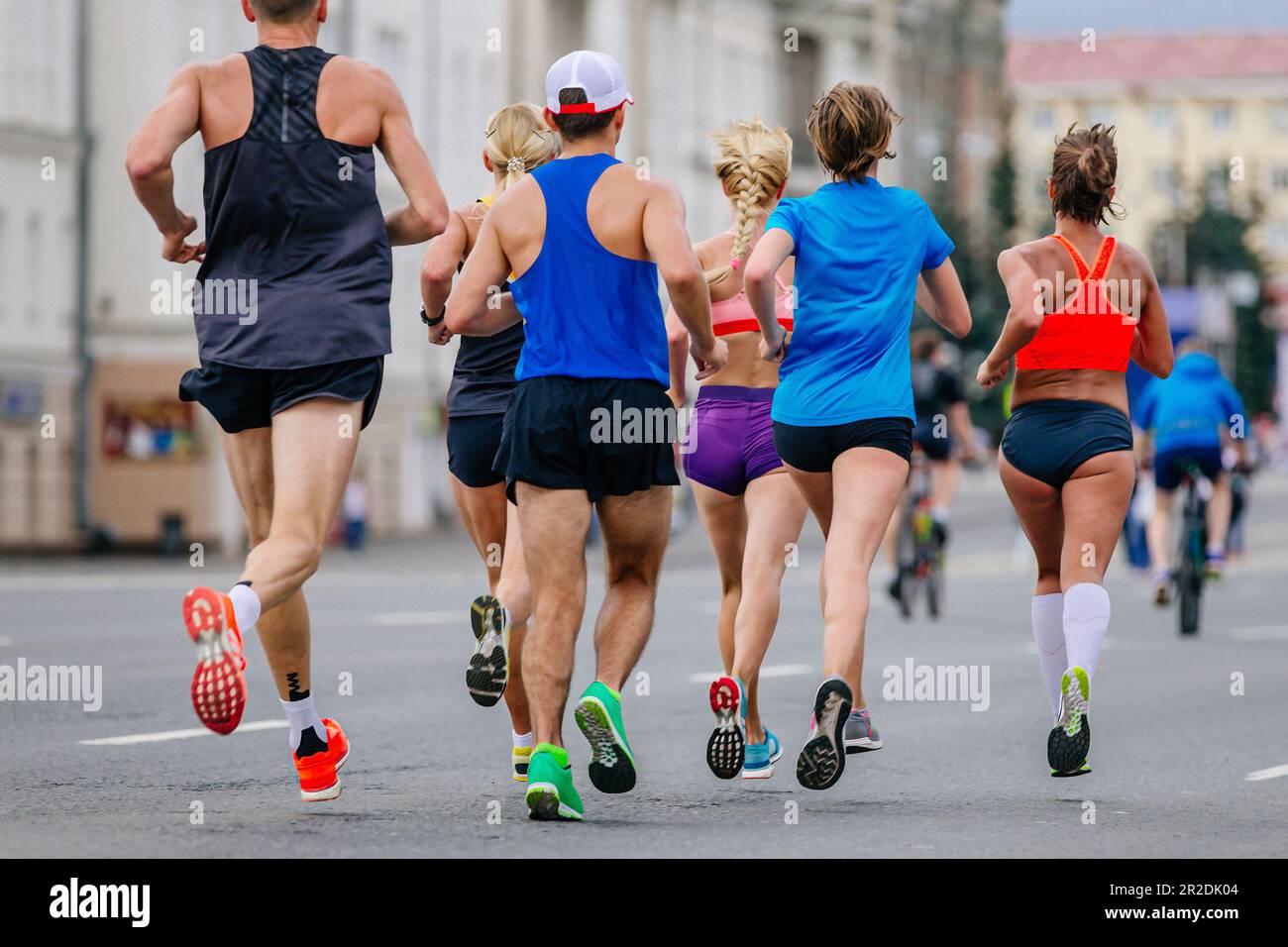 atleti di gruppo misto che corrono maratona in città, uomini e donne joggers gara sportiva estiva Foto Stock