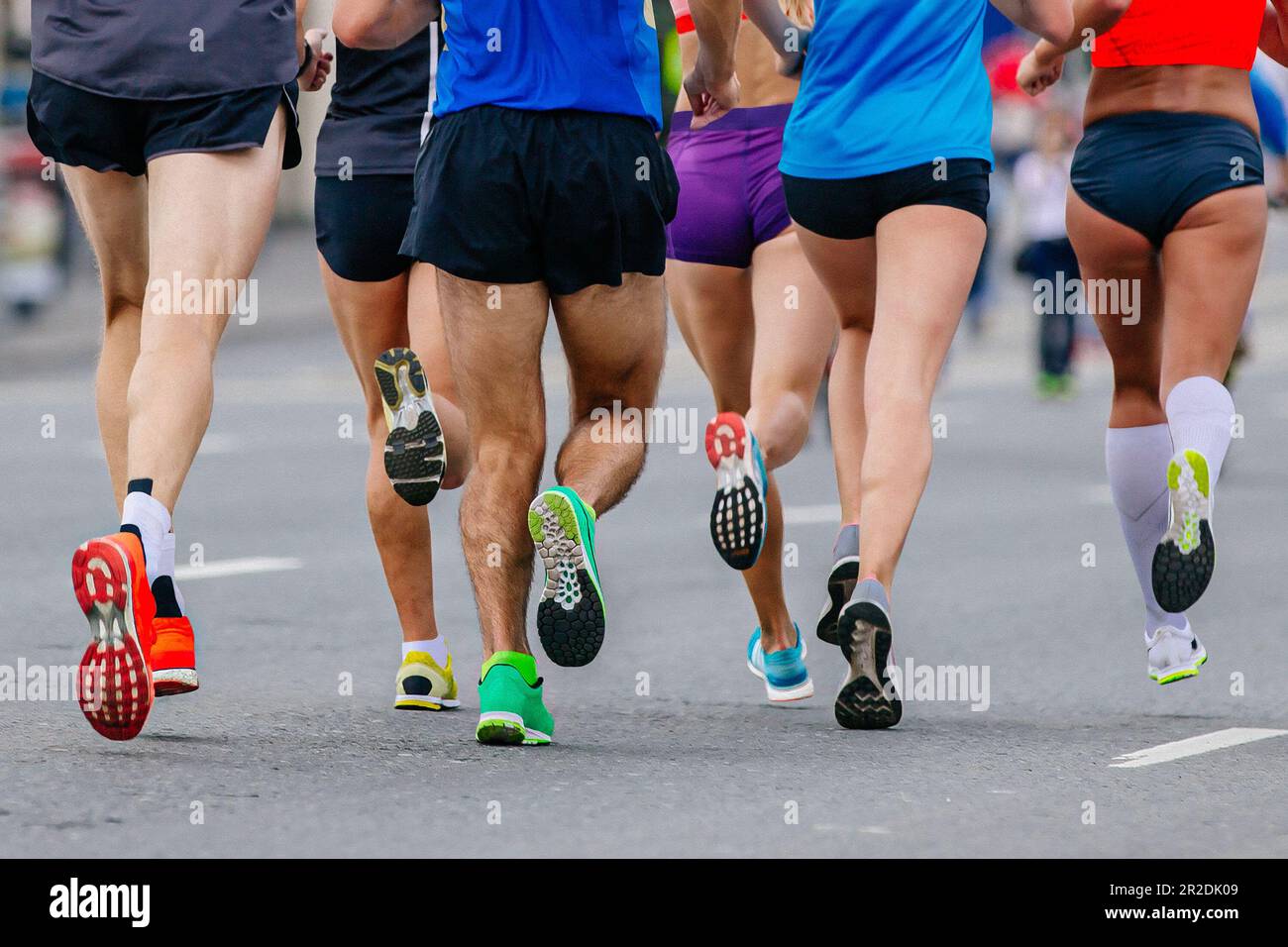 gambe di gruppo misto corridori atleti che corrono maratona in strada, uomini e donne joggers gara sportiva estiva Foto Stock