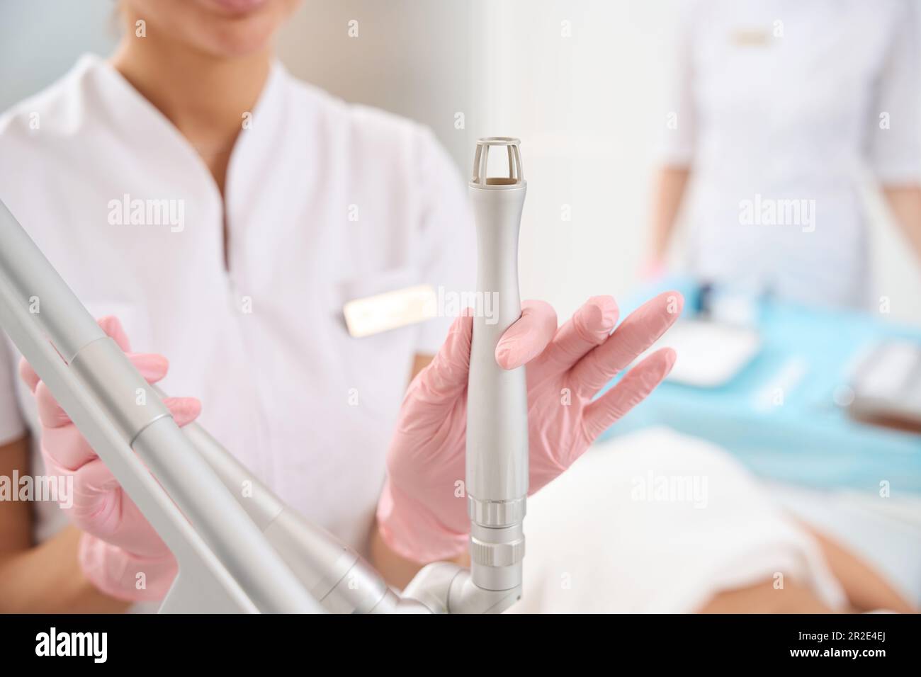 La clinica di medicina estetica del dipendente tiene lo strumento di pelatura laser in mano Foto Stock