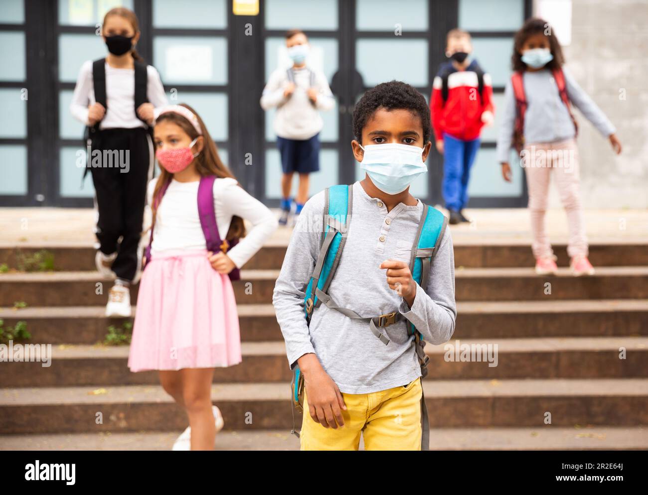 Scolboy afro-americano Tween in maschera protettiva andare a scuola Foto Stock