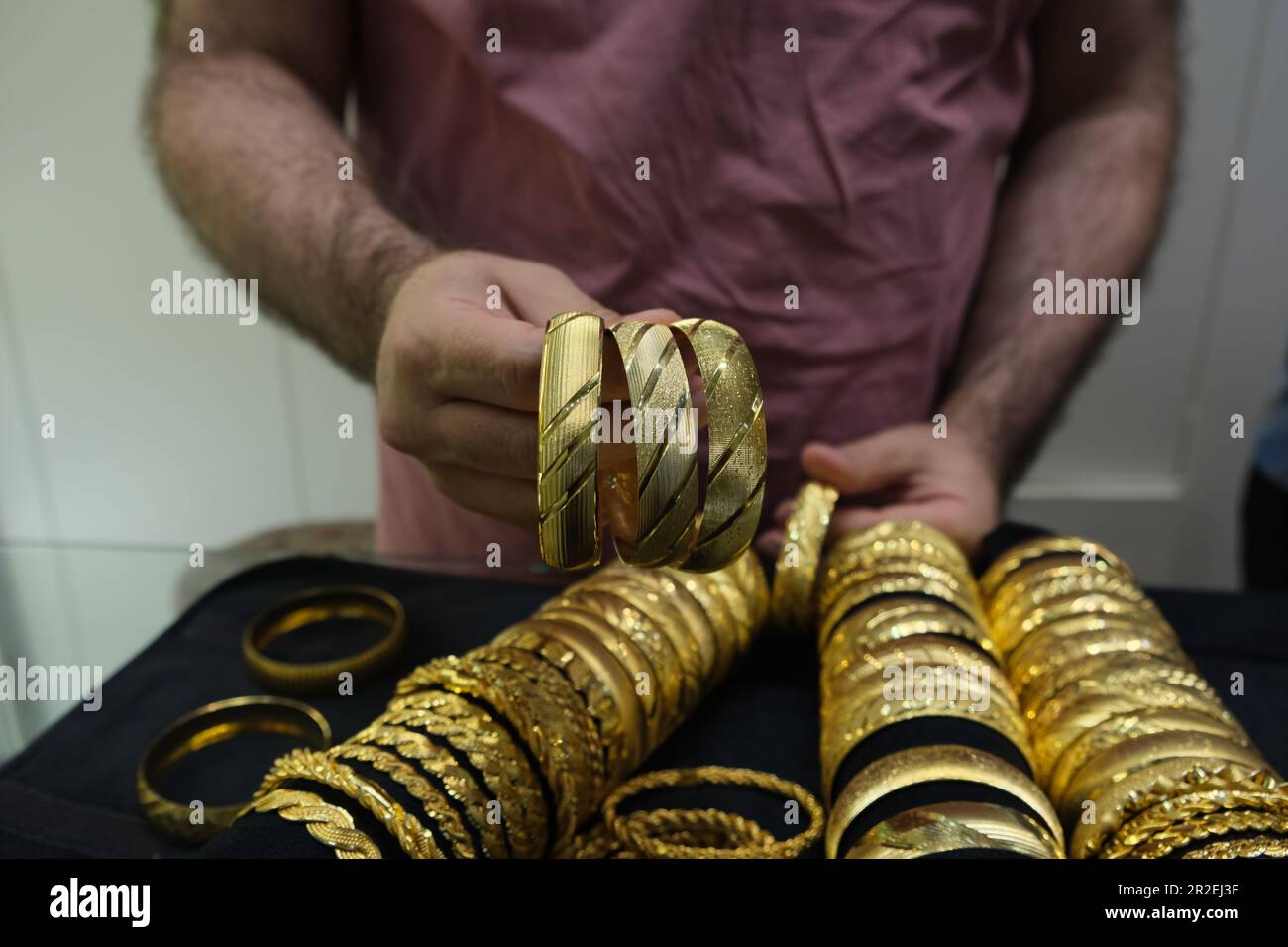 Braccialetti dorati in gioielleria con mano d'uomo, shopping in Turchia idea di foto concetto. Foto Stock