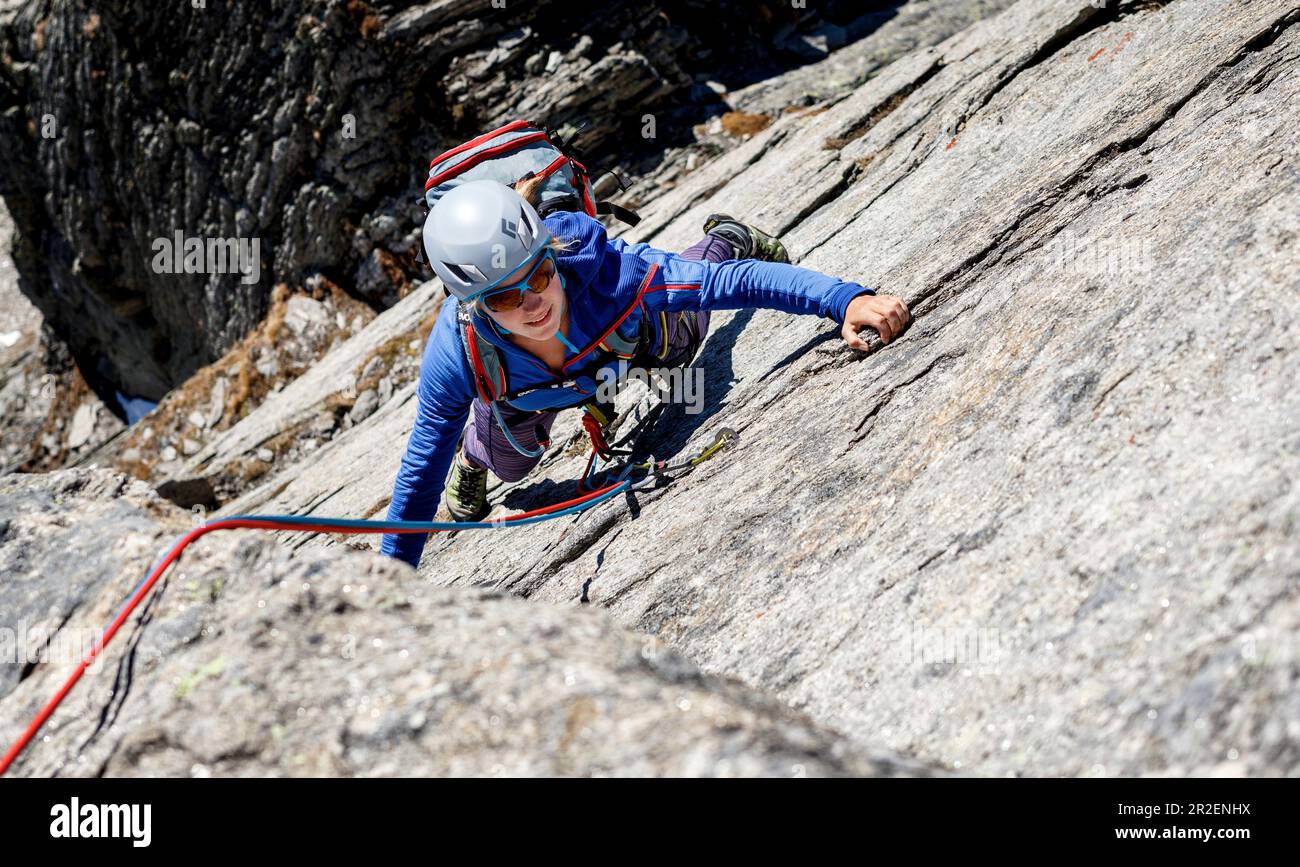 Giovane arrampicatore sale su una corda in granito, Gigalitz, Alpi della Zillertal, Tirolo, Austria Foto Stock