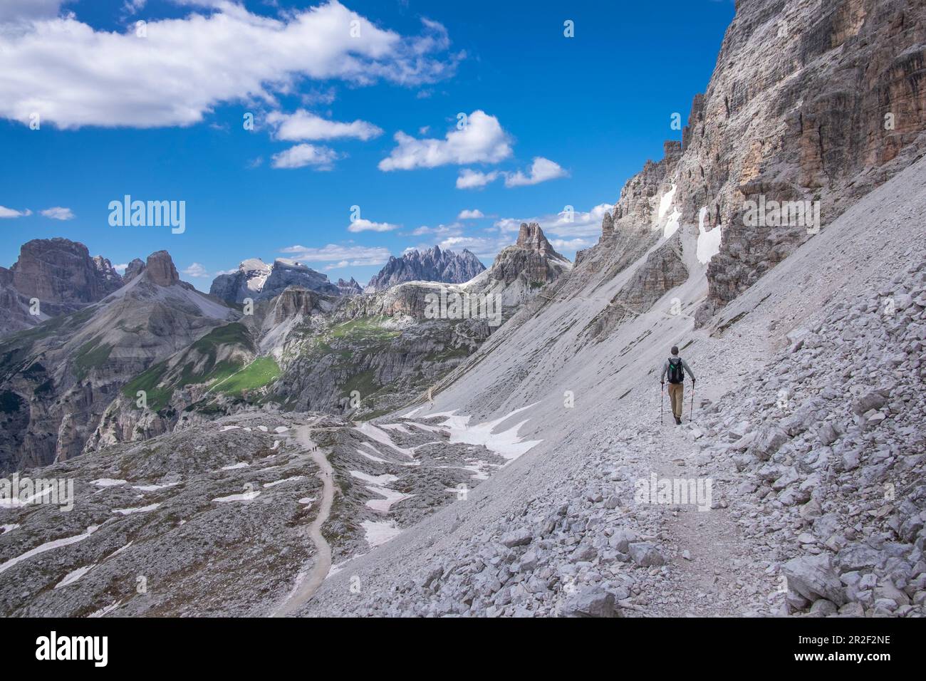 Uomo escursionistico sotto il Paternkofel alle tre vette del Parco Naturale Dolomiti, Alto Adige Foto Stock