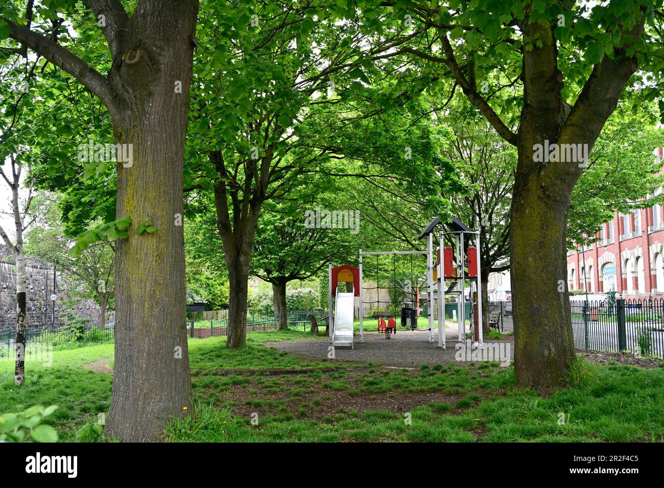 Un piccolo parco tascabile della città centrale con alberi e area giochi per bambini a Easton, Bristol, Regno Unito Foto Stock