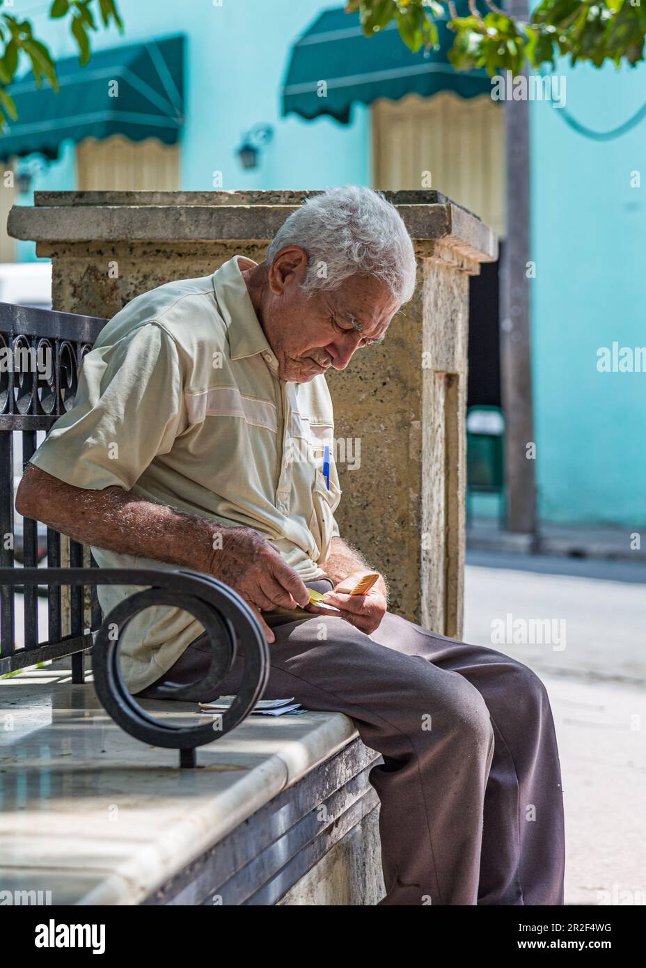 Anziano cubano seduto su una panchina del parco, Camagüey, Cuba Foto Stock