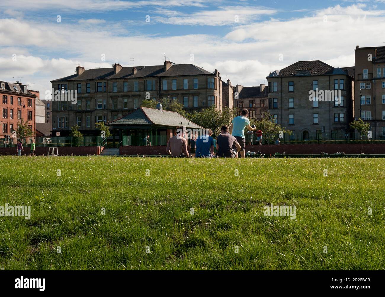 I ragazzi giocano a bocce di fronte al padiglione del campo da bowling Kelvingrove a Glasgow, Scozia, Regno Unito Foto Stock