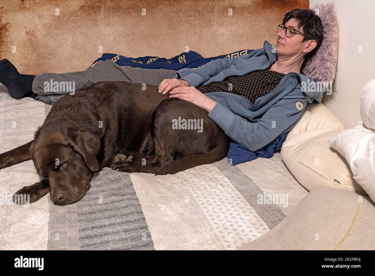 Giovane donna con il suo Labrador dormiente, Baden-Wuerttemberg, Germania Foto Stock