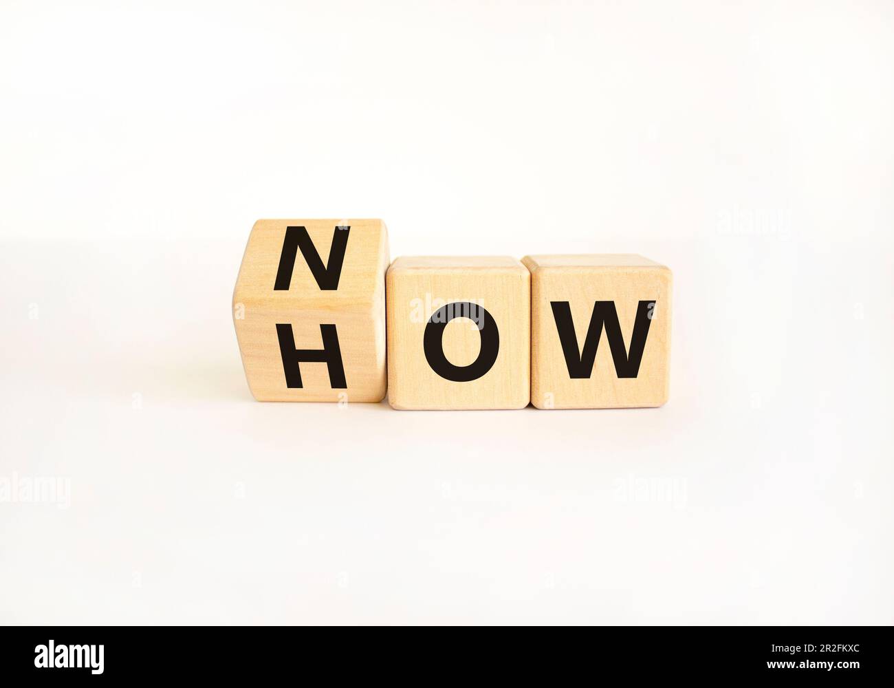 Sapere come simbolo. Uomo d'affari gira cubi di legno e cambia la parola come sapere. Bellissimo sfondo bianco tavolo. Spazio di copia. Business e kno Foto Stock