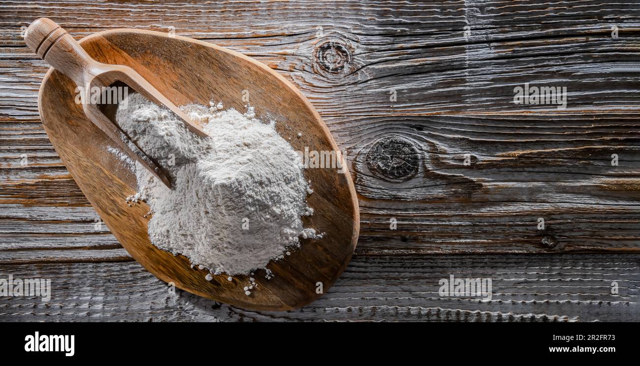 Farina di grano sul tagliere di legno Foto Stock
