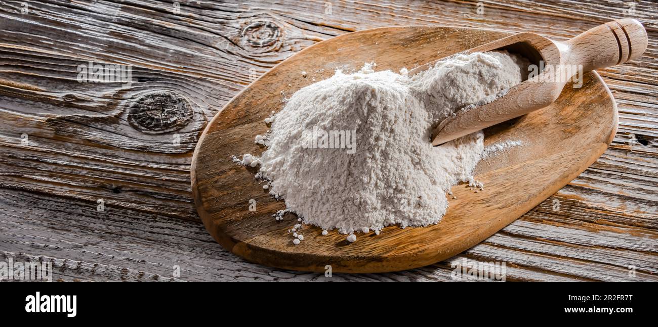 Farina di grano sul tagliere di legno Foto Stock