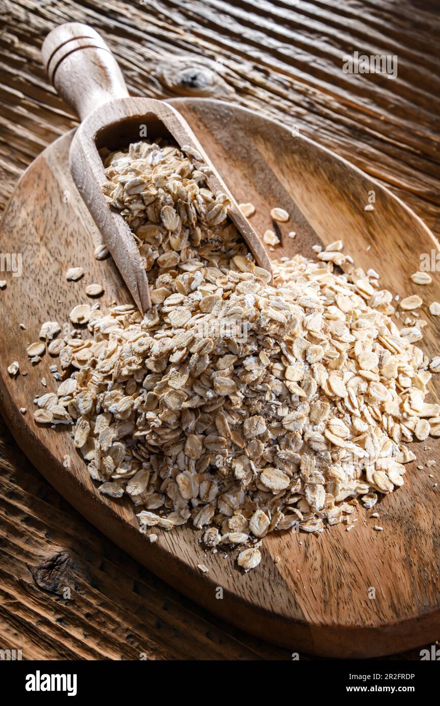 Avena arrotolata sul tagliere di legno Foto Stock