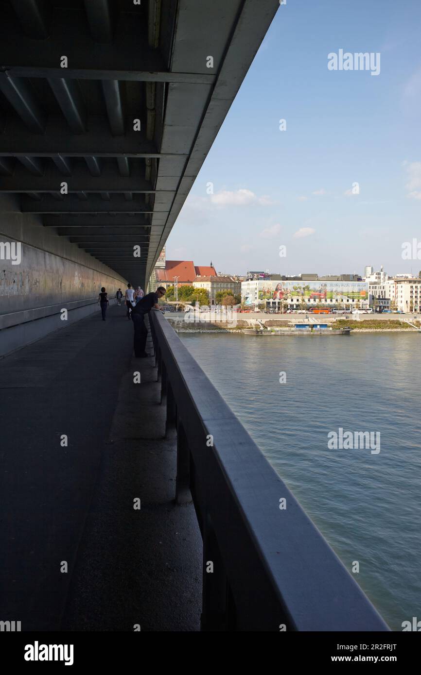 Passeggiata sul ponte della rivolta nazionale slovacca (slovacco ufficialmente la maggior parte SNP) con Danubio e le facciate delle case, Bratislava, Slovacchia Foto Stock
