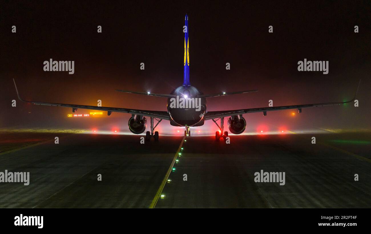 Airbus A320 di notte e nebbia di fronte alla pista all'aeroporto di Monaco, Baviera, Germania Foto Stock