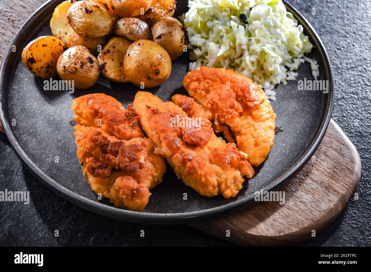 Cotolette di pollo impanate servite con patate e cavolo Foto Stock