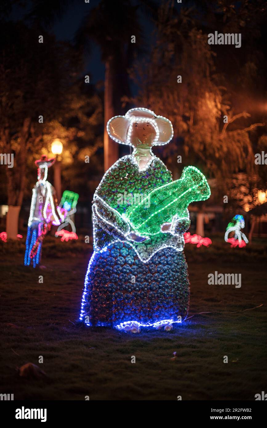 Figura indogena illuminata fatta di bottiglie di plastica di notte, Parque Principal, Barichara, Departmento de Santander, Colombia, Sud America Foto Stock