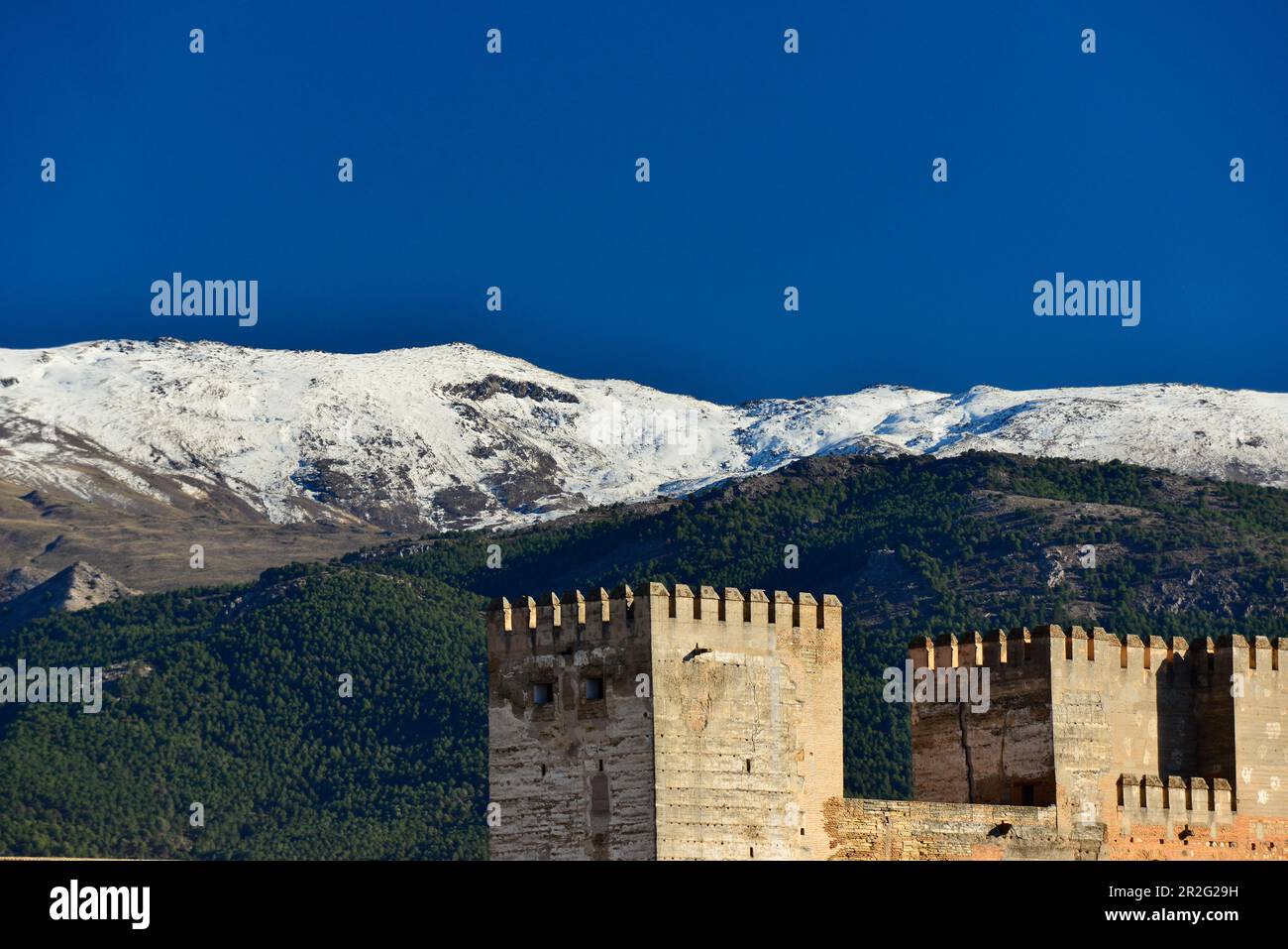 Vista delle torri di difesa dell'Alhambra e della Sierra Nevada sullo sfondo, Granada, Andalusia, Spagna Foto Stock