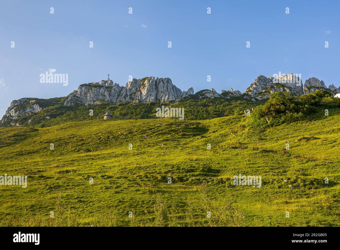 Vista dal basso del Kampenwand con la croce sommitale e la cappella. Hphenaschau, Chiemgau Alps, Chiemgau, alta Baviera, Baviera, Germania, Europa Foto Stock