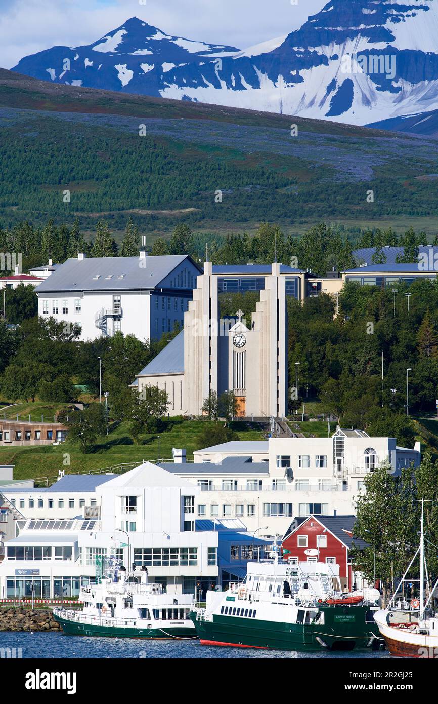 Vista sul porto fino all'imponente chiesa evangelica luterana di Akureyrarkirkja, su una collina, con molte vetrate colorate e un grande organo. Foto Stock