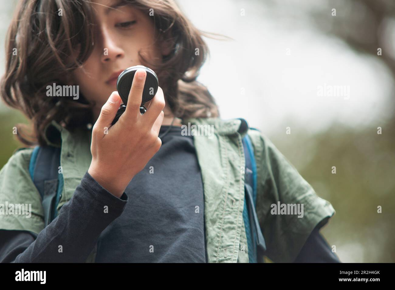 Un primo piano di un ragazzo che fissava con intelligenza una bussola, affidandosi alla sua guida per navigare. Foto Stock