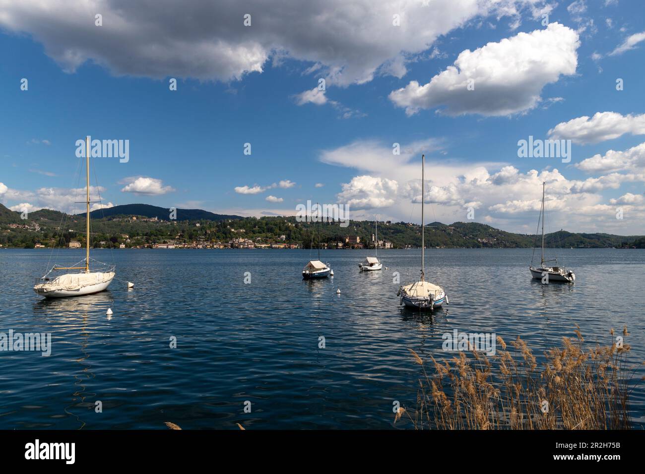 Cinque barche a vela ormeggiate sul lago d'Orta, vicino a Pella, Piemonte, Italia. Foto Stock