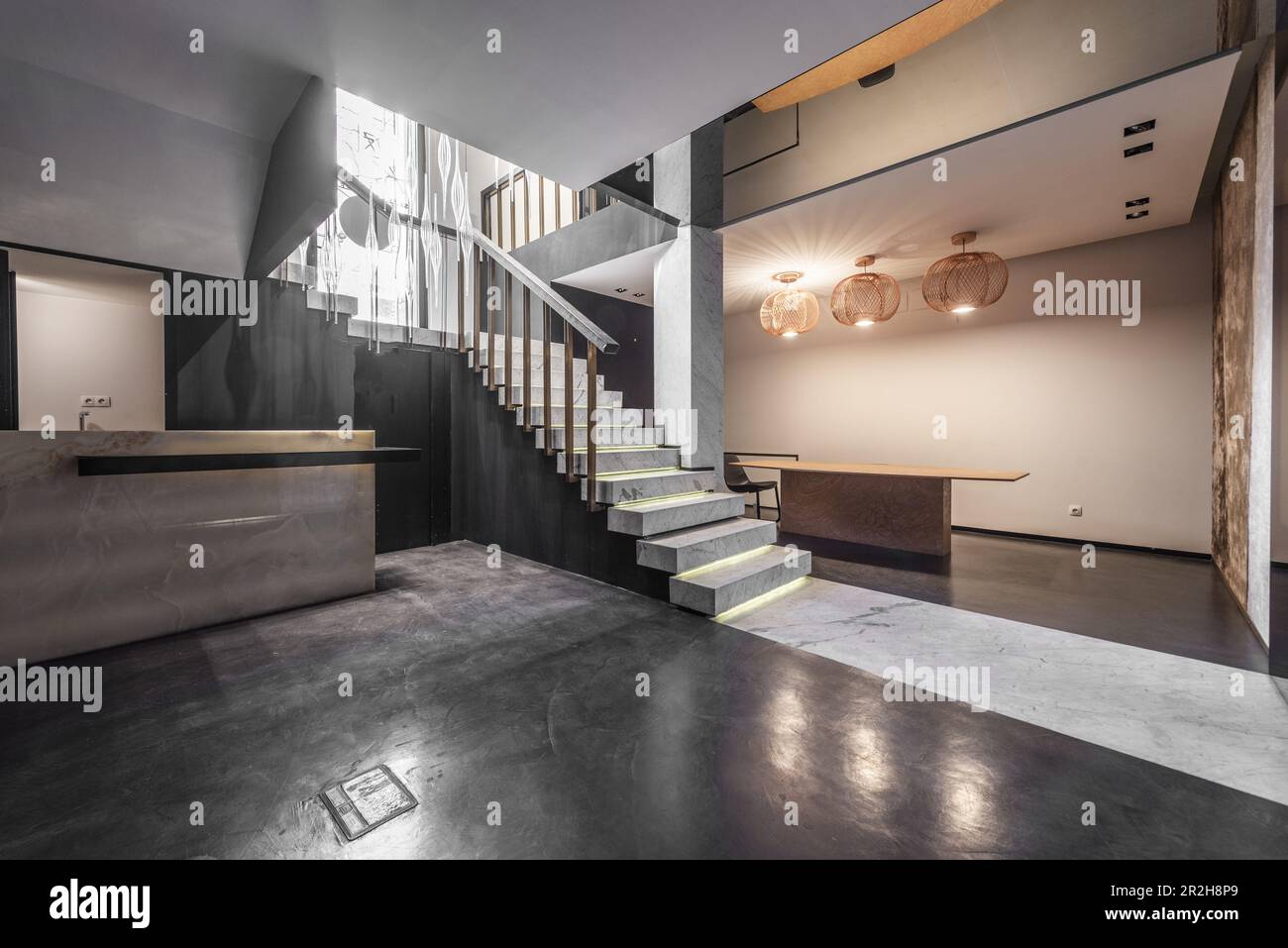 Piano terra di uno spazio vuoto con esposizione di piastrelle di marmo e pavimenti in cemento lucidato e scale con gradini in marmo Foto Stock