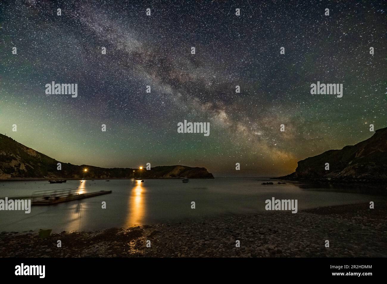 Il centro galattico della Via Lattea risplende nel cielo limpido di notte sopra Lulworth Cove in Dorset. Foto Stock