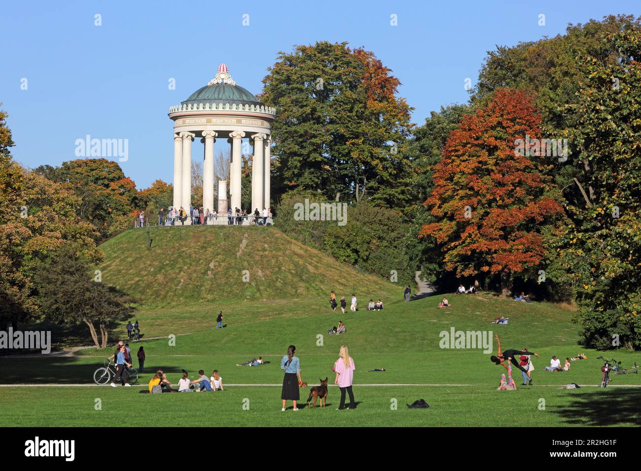 La gente può trascorrere un pomeriggio autunnale nel Giardino Inglese, con i Monotteri sullo sfondo, Monaco, alta Baviera, Baviera, Germania Foto Stock