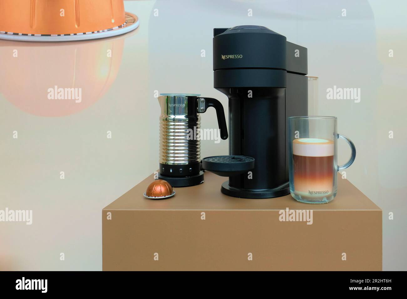 Macchina da caffè automatica Nespresso Vertuo con cialda, tazza con latte finto; vetrina dell'apparecchio per la cucina domestica. Foto Stock