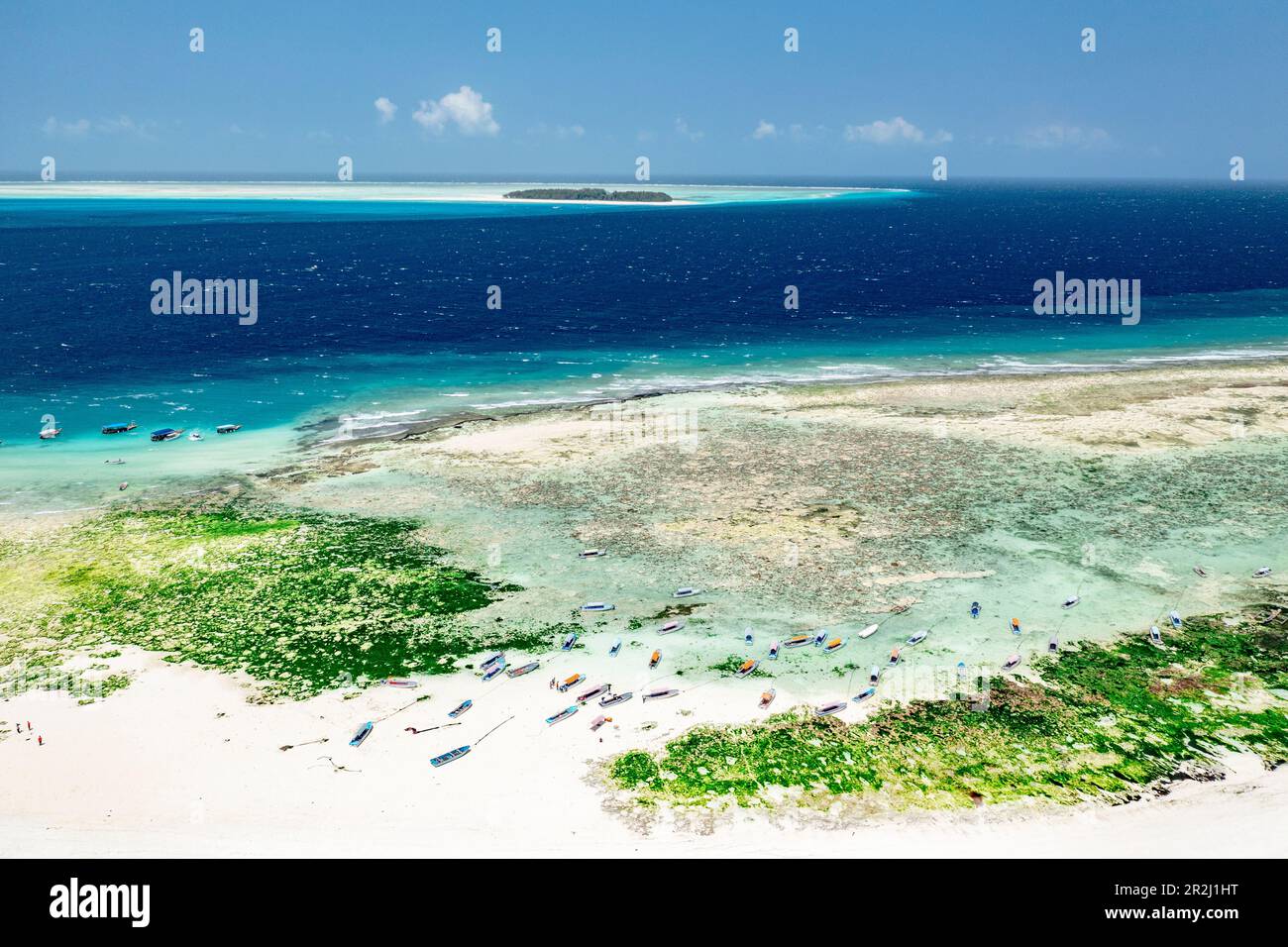 Barche su idilliaca spiaggia di sabbia con l'isola di Mnemba sullo sfondo, Zanzibar, Tanzania, Africa orientale, Africa Foto Stock