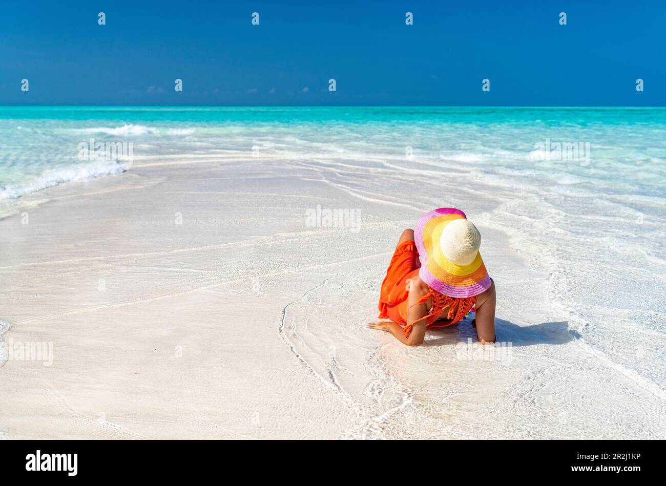 Donna con cappello rilassante su idilliaca spiaggia vuota, Zanzibar, Tanzania, Africa orientale, Africa Foto Stock