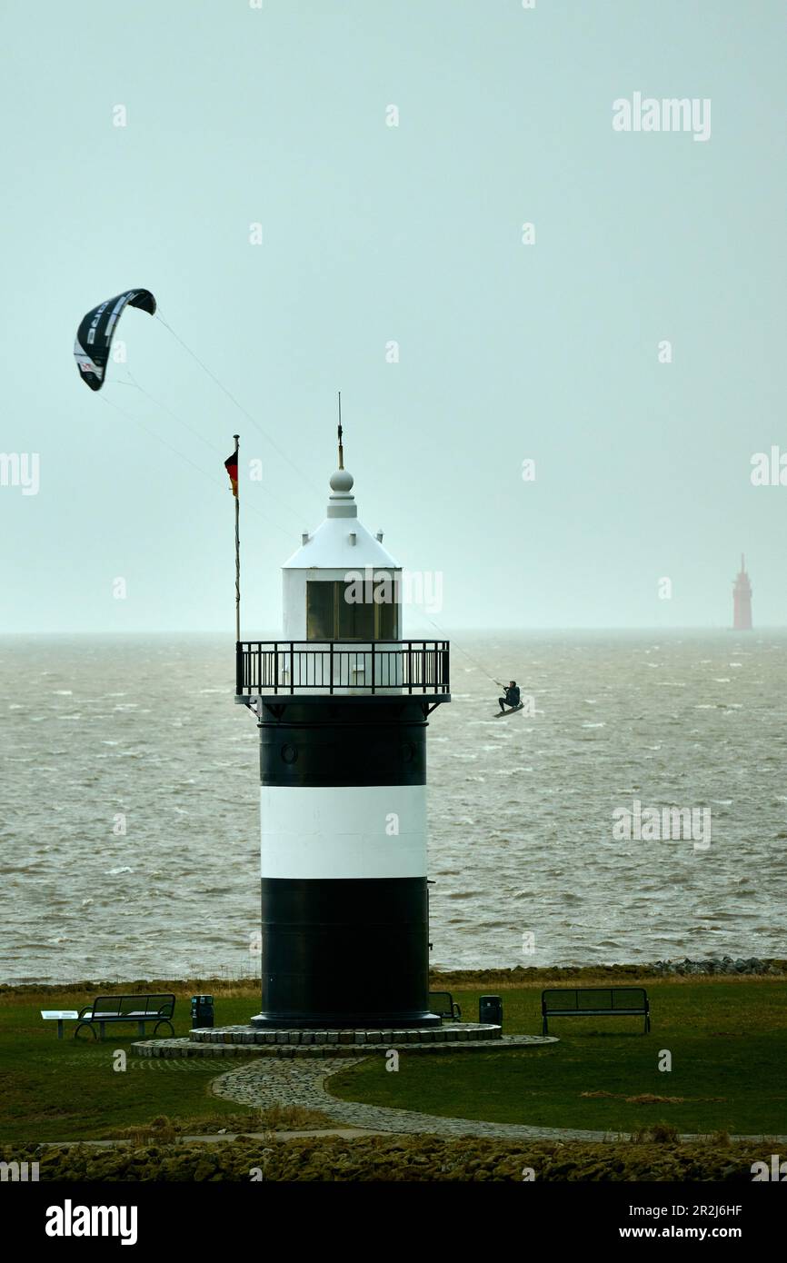 Un kitesurfer circumnaviga il faro di &#39;Kleiner Preusse'39; a Wremen, distretto di Cuxhaven, bassa Sassonia, Germania Foto Stock