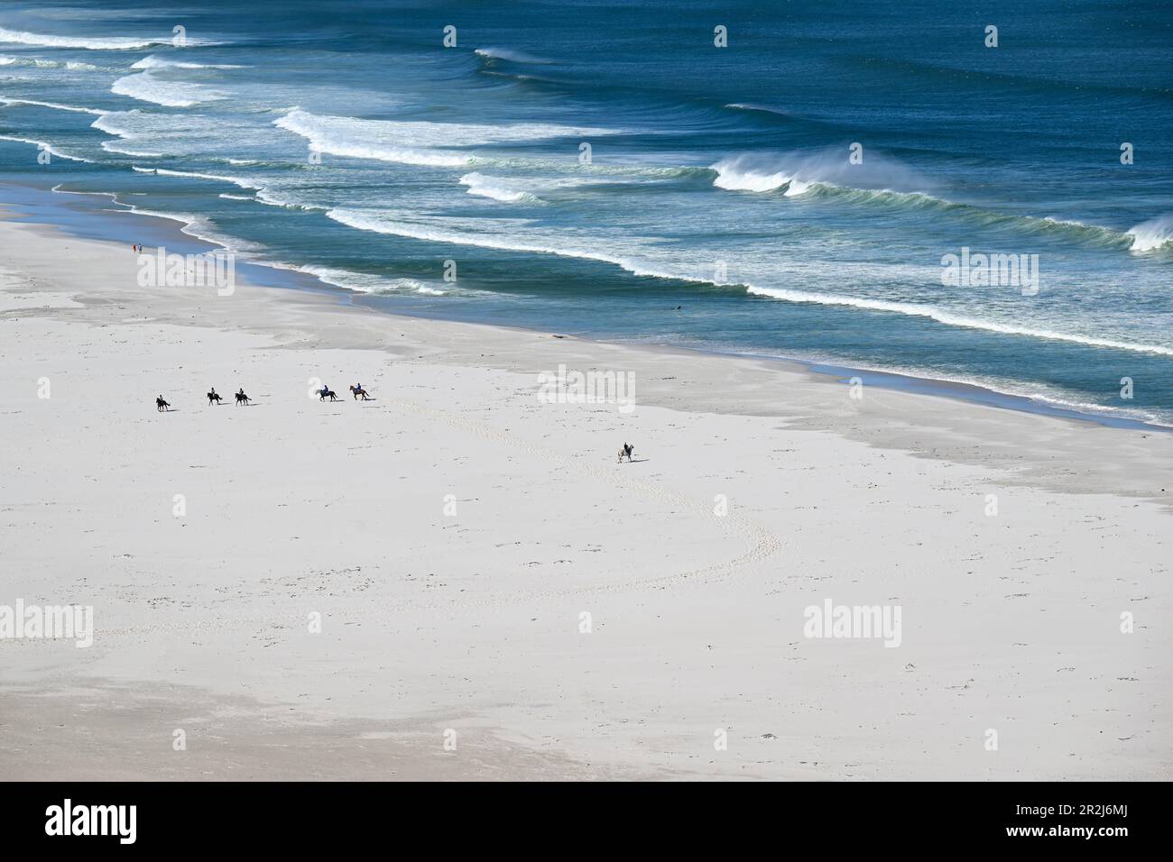 Cavalieri a cavallo sulla spiaggia di Nordhoek, Cpae occidentale, Sudafrica Foto Stock