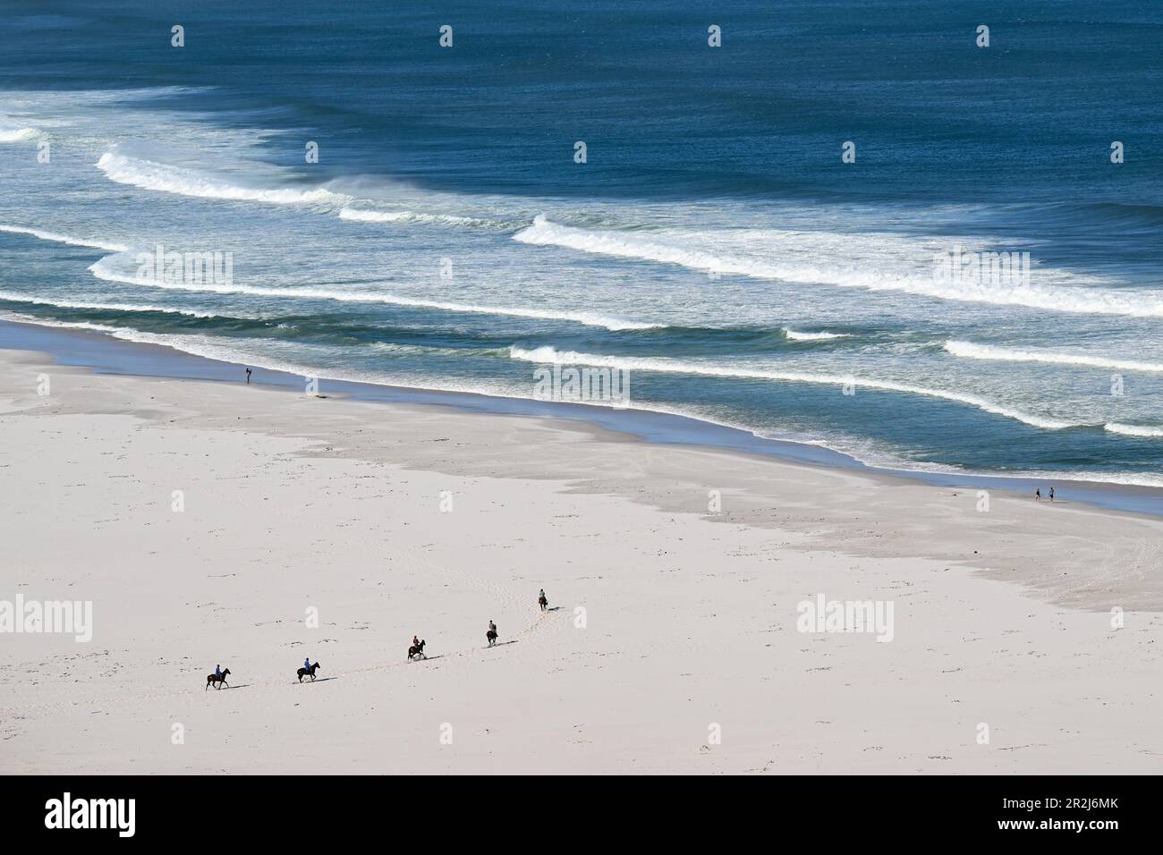 Cavalieri a cavallo sulla spiaggia di Nordhoek, Cpae occidentale, Sudafrica Foto Stock