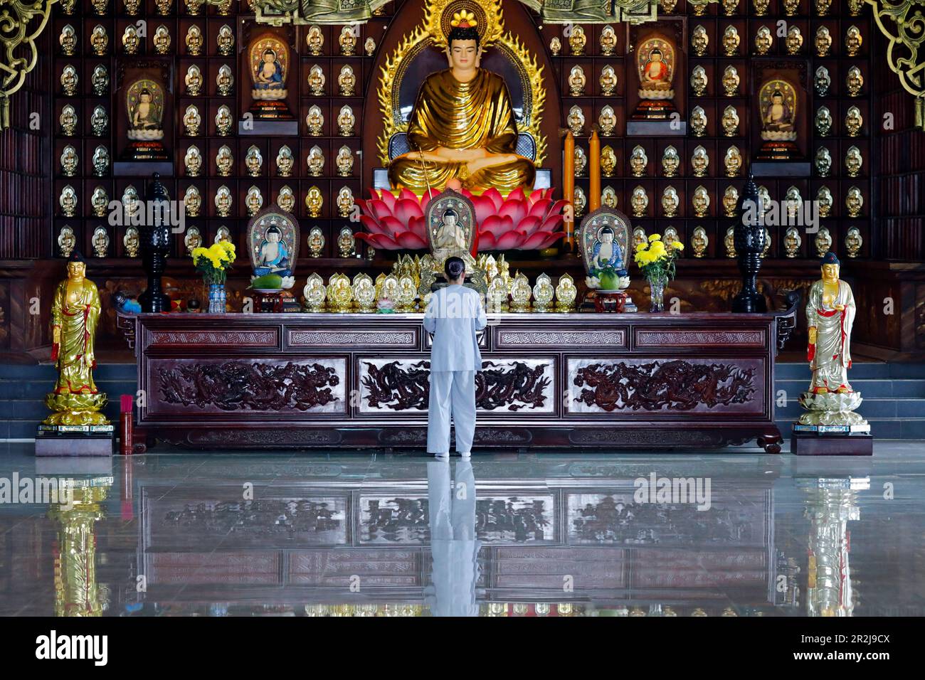 Donna che prega all'altare maggiore, al tempio buddista di Phat Quang, a Siddhartha Gautama (il Buddha Shakyamuni), a Chau Doc, in Vietnam, a Indocina, nel sud-est asiatico Foto Stock
