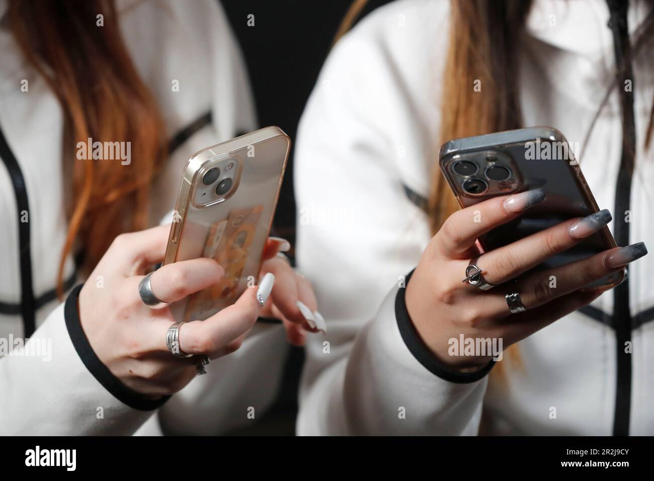 Mani femminili con smartphone primo piano, due donne che utilizzano telefoni cellulari, Francia, Europa Foto Stock