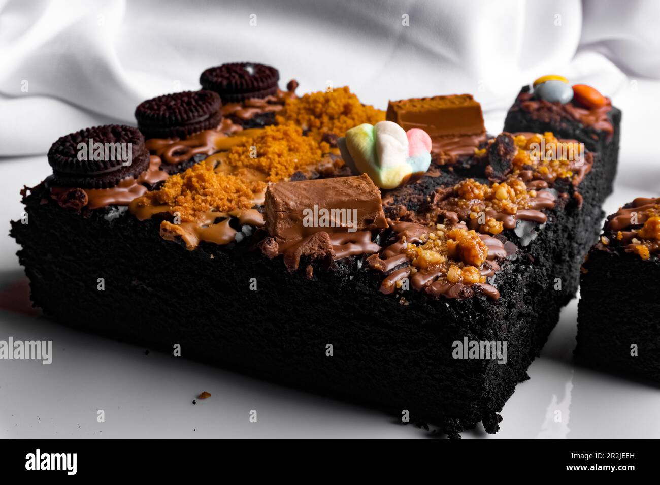 Pezzi di brownie fresco su sfondo bianco. Torta al cioccolato deliziosa e dolce Foto Stock