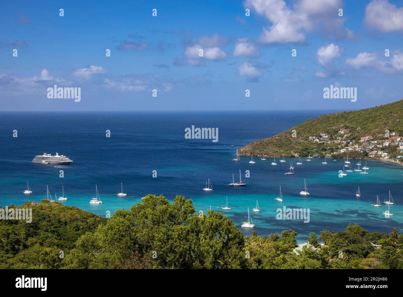 Vista su World Voyager (Nicko Cruises) nave da crociera spedizione e barche a vela nel porto, Port Elizabeth, Bequia Island, Grenadine, Saint Vincent e The Foto Stock